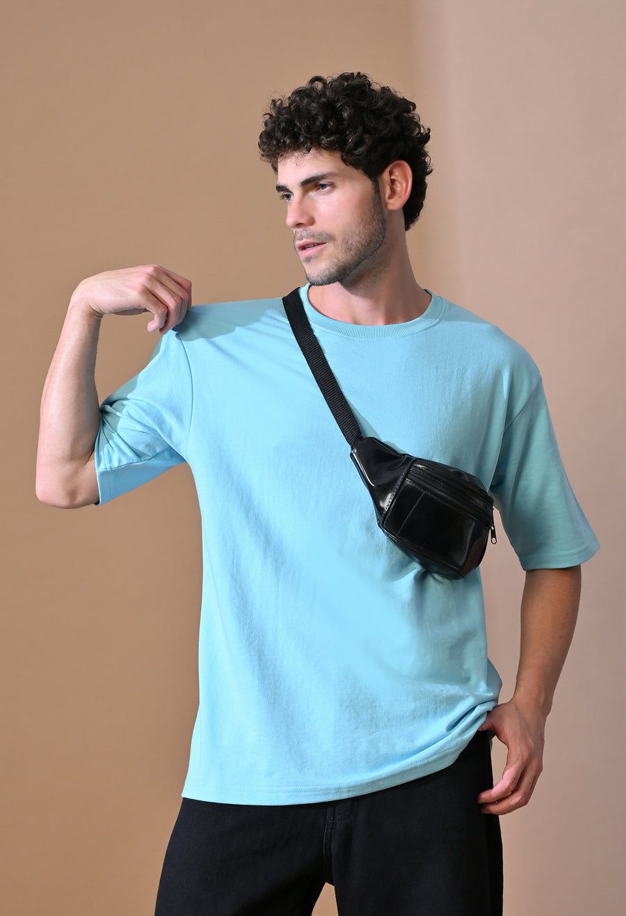 Man wearing the Aqua Breeze Oversized Tee with a crossbody bag