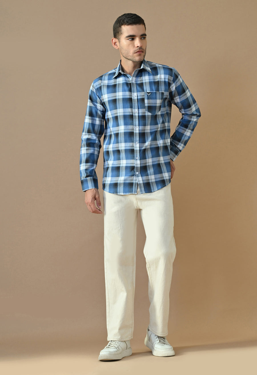 Man wearing Cobalt Check Button-Up Shirt with white trousers