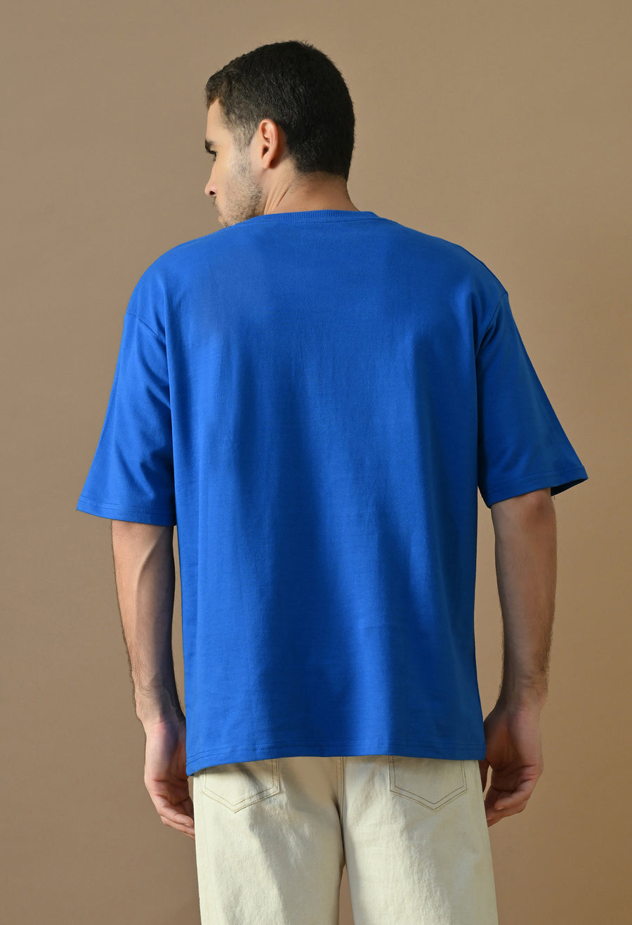 Man wearing a royal blue oversized t-shirt, back view