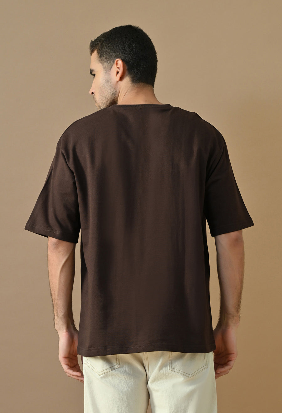 Man wearing OUTSYN Oak Bourbon Oversized T-Shirt, back view